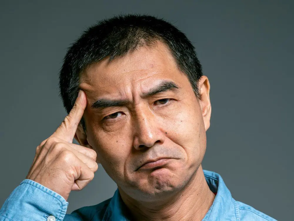 man pointing to forehead